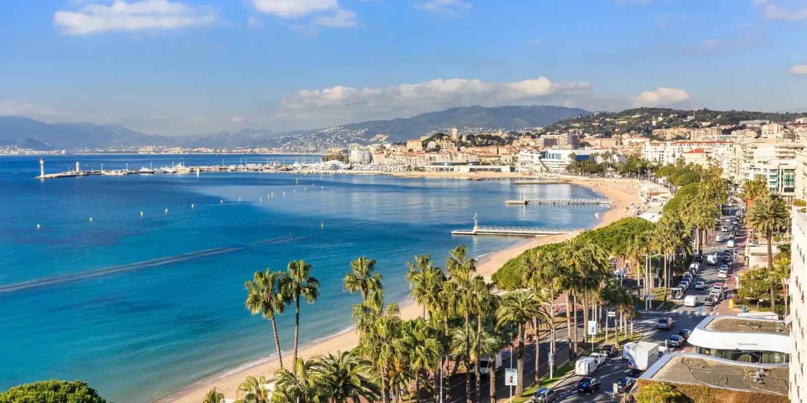 Luxury Yacht Charter Cannes: Beyond the Croisette La Croisette seafront in Cannes with luxury yachts anchored offshore