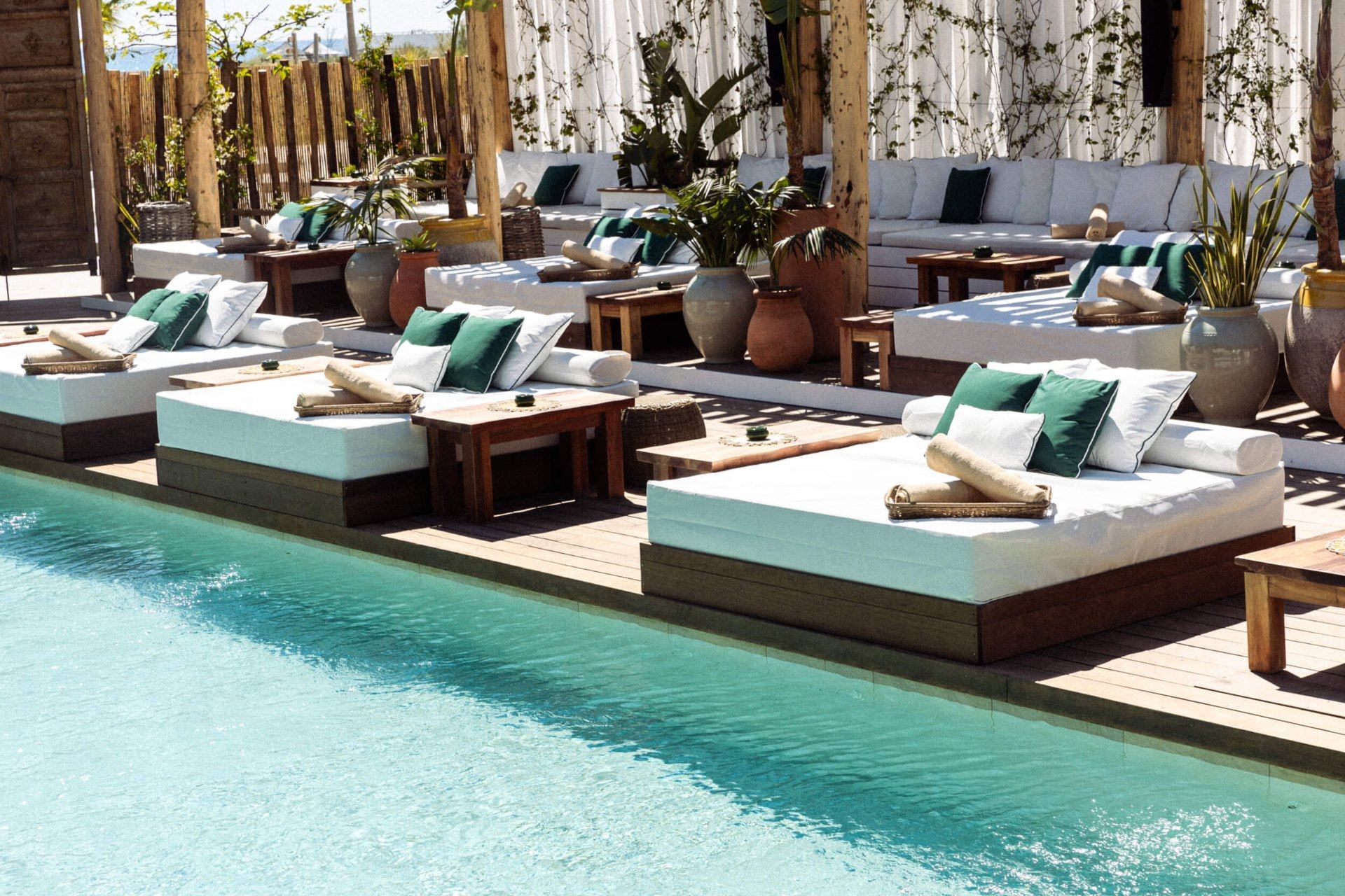 Saint-Tropez Hotels with Yacht Marina Access & Private Boat Charters Exclusive beach club with poolside daybeds overlooking yachts in Saint-Tropez
