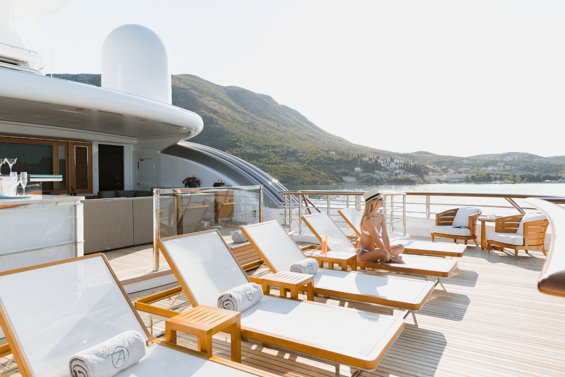 Monaco Superyacht Charter Prices and Options Luxury superyacht sundeck with loungers overlooking the Mediterranean