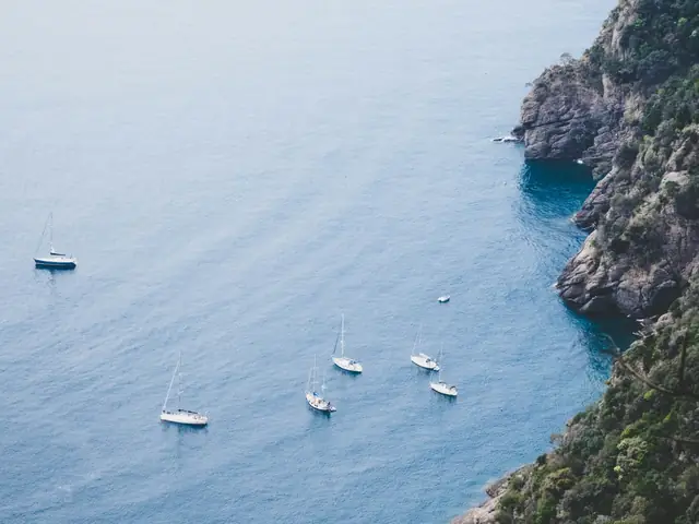 San Fruttuoso: Wooded Ligurian cliffs above the sea with sailing boats