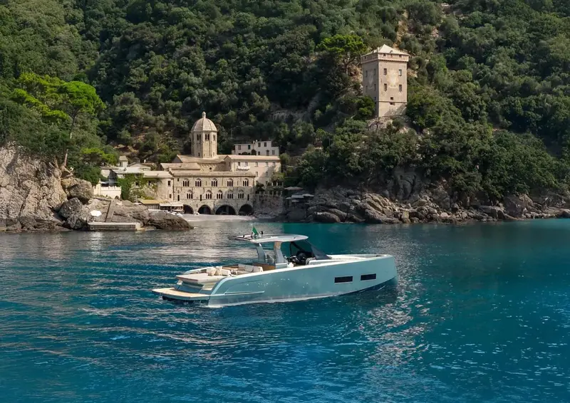 Private yacht at anchor below a Riviera village