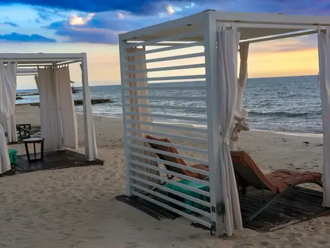 Mood photo (not the venue): White beach cabanas at sunset