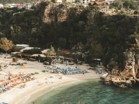 Mood photo (not the venue): Loungers and parasols in a sheltered cove