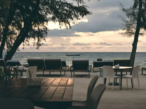 Mood photo (not the venue): Beach terrace tables at sunset