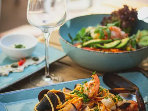 Mood photo (not the venue): Clams and a glass of white wine on the table