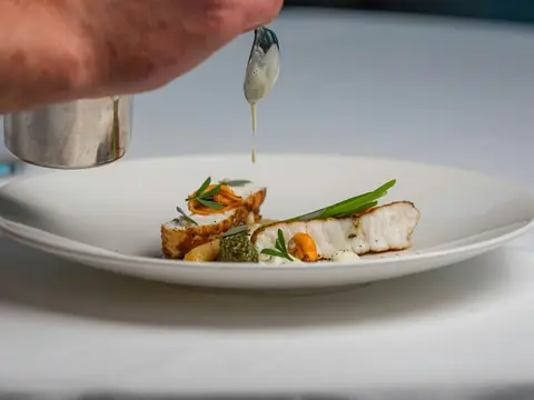 Mood photo (not the venue): Fish and vegetables plated on white porcelain