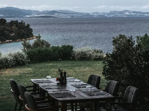 Mood photo (not the venue): Outdoor dining table overlooking the sea